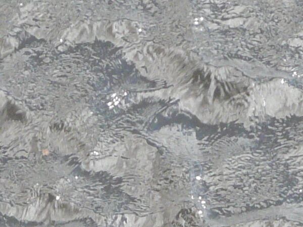 Deep water texture in dark grey tone with small waves and glossy surface.