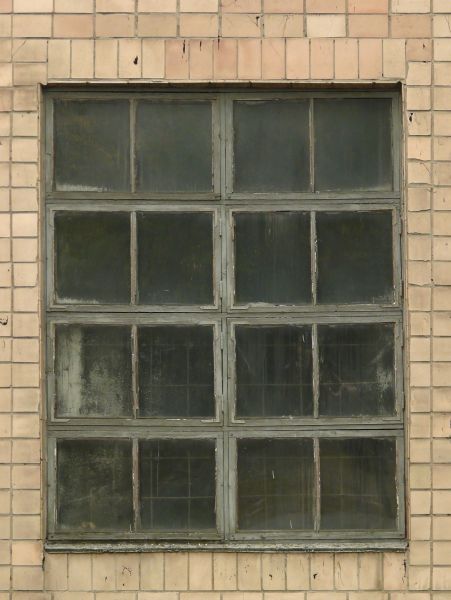 Grey windows texture with rough chipping paint on the trim and tan brick surrounding them. A metal grid is faintly visible inside, and various paint marks are on the glass.