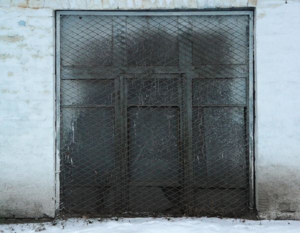 Black metal window texture with with white spray painted areas on the top and sides, and a wire lattice set over it.