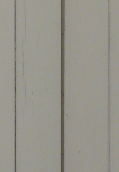 White window texture closed by shutters with very little wear, set in a worn brown wall with white bricks and specks of black.