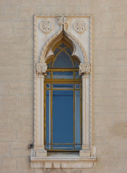 Arched window texture, with various tracery and moldings in the stone and gold painted wood separating the window panes.