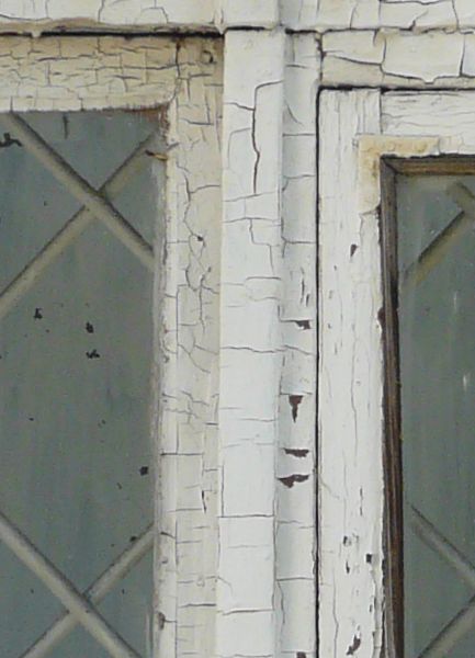 Stone framed window texture, with square panes divided by wood with cracking white paint. A diamond-shaped lattice pattern is embedded into each pane of glass.