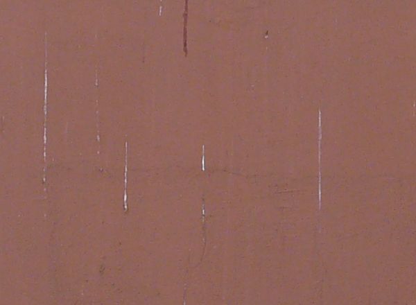 Window texture closed with well-worn grey shutters with rusted hinges. The two windows are surrounded by white stone frames within a slightly stained, rose colored wall.