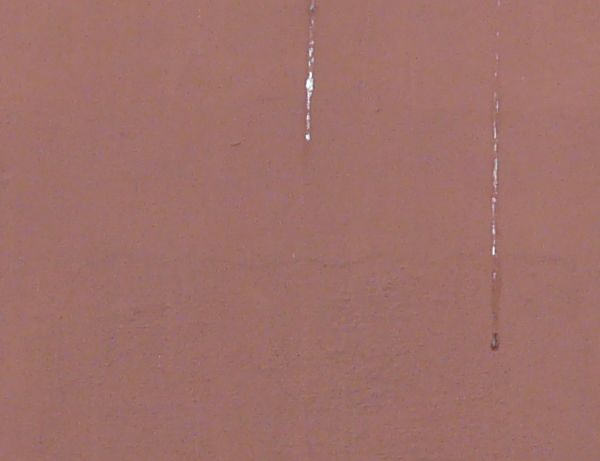 Window texture closed with well-worn grey shutters with rusted hinges. The two windows are surrounded by white stone frames within a slightly stained, rose colored wall.