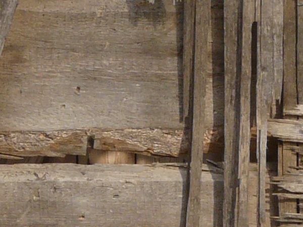 Texture of wooden wall with very worn, damaged surface.