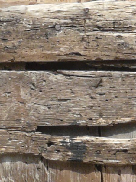 Wooden plank texture set in irregular formation with very rough, worn surface.