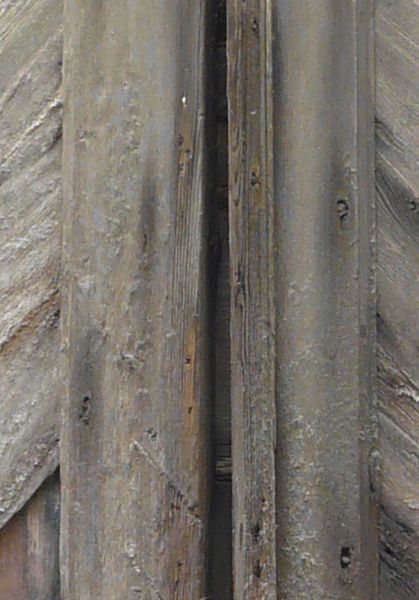 Old, wooden panels with very worn surface and splintered bottom edge.