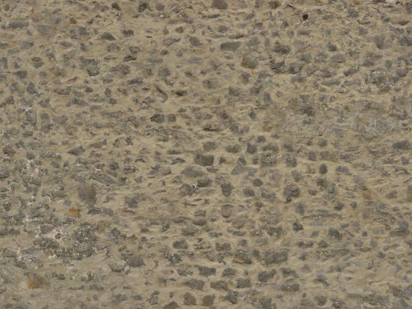 Medieval stone wall of grey stones of various shapes in thick, beige concrete.