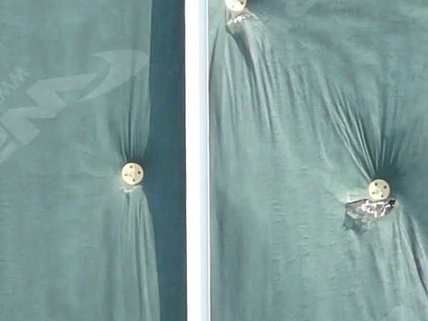 Wall texture, covered by pieces of thin green plastic divided by thin white strips. A worn black surface is visible behind some of the plastic.