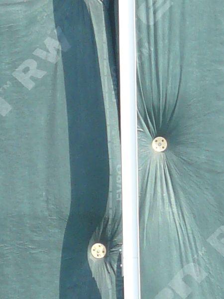 Wall texture, covered by pieces of thin green plastic divided by thin white strips. A worn black surface is visible behind some of the plastic.