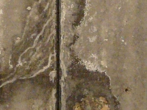 Large, rectangular blocks of concrete with irregular surface and large hole exposing metal armature.