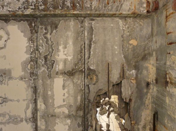 Large, rectangular blocks of concrete with irregular surface and large hole exposing metal armature.