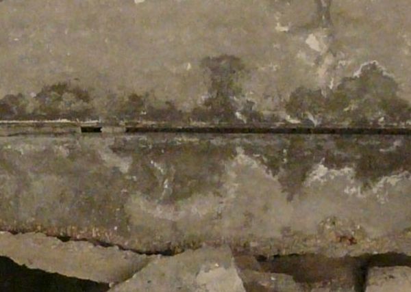 Large, rectangular blocks of concrete with irregular surface and large hole exposing metal armature.