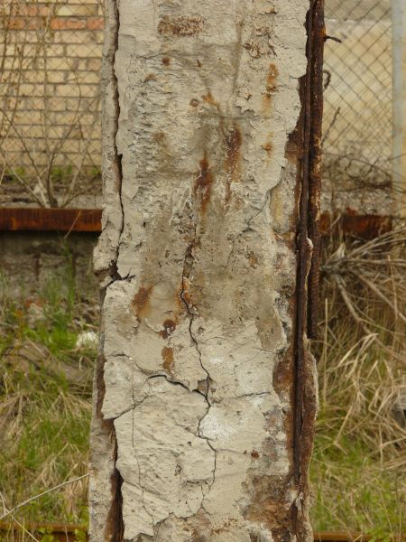 Concrete pillar texture with very rough, damaged surface and rusty edges.