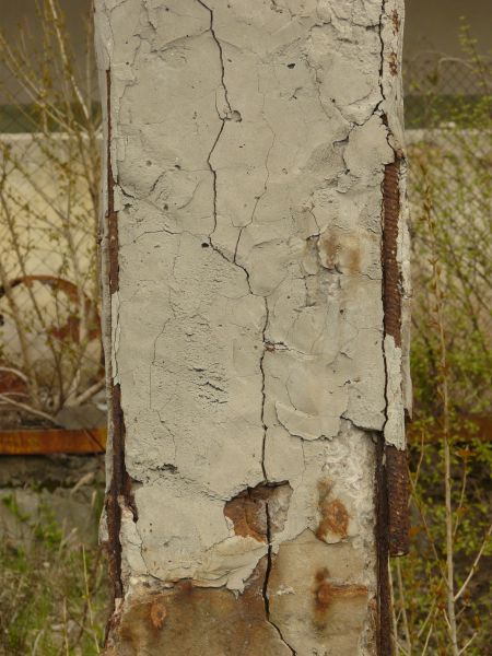 Concrete pillar texture with very rough, damaged surface and rusty edges.