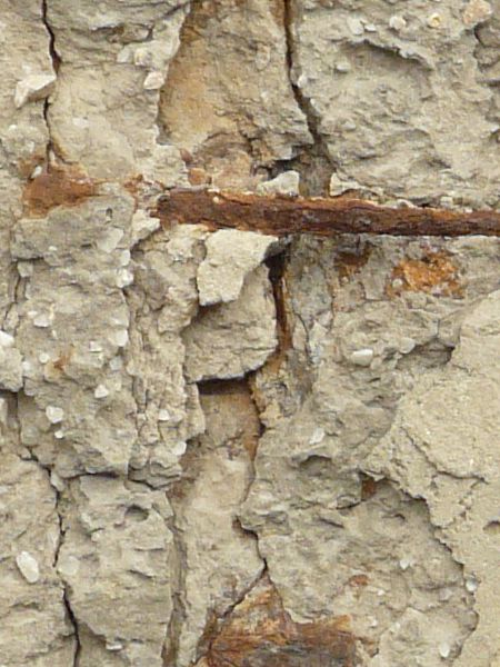 Concrete pillar texture with very rough, damaged surface and rusty edges.