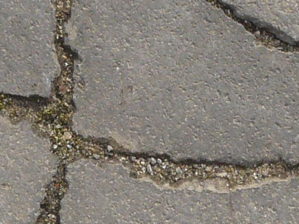 Texture of concrete in grey tone with cracked surface and dirt in cracks.