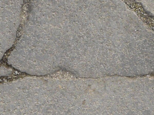 Texture of concrete in grey tone with cracked surface and dirt in cracks.