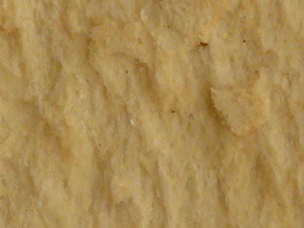 Old foam paneling in yellow tone with worn, damaged surface.