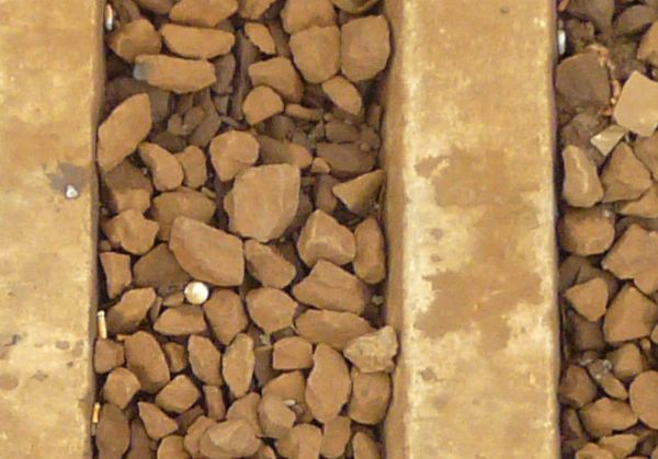 Railroad texture, partly covered by the surrounding brown rocks.