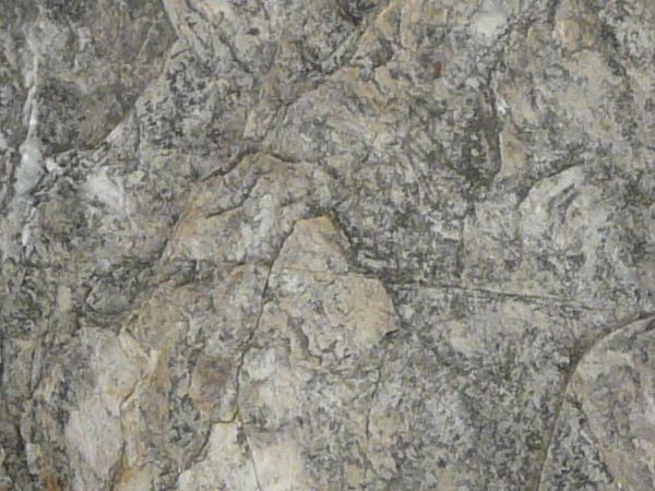 Rock texture in mixed tones of grey and brown with thin lines throughout surface.