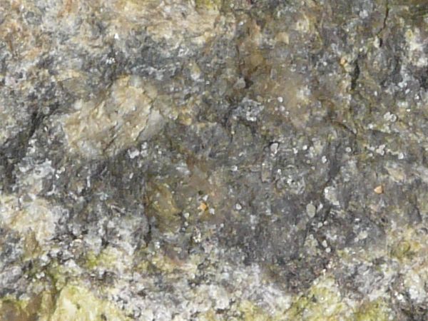 Rock texture in mixed grey and beige tones with very rough, irregular surface.