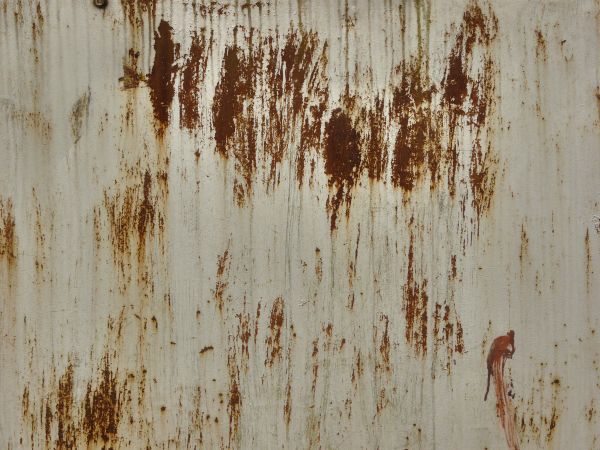 White metal texture with large, irregular patches of red rust and many small rusted scratches.