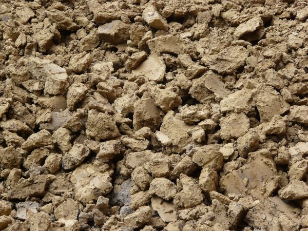 Brown soil texture, dried into large, rough-edged chunks.