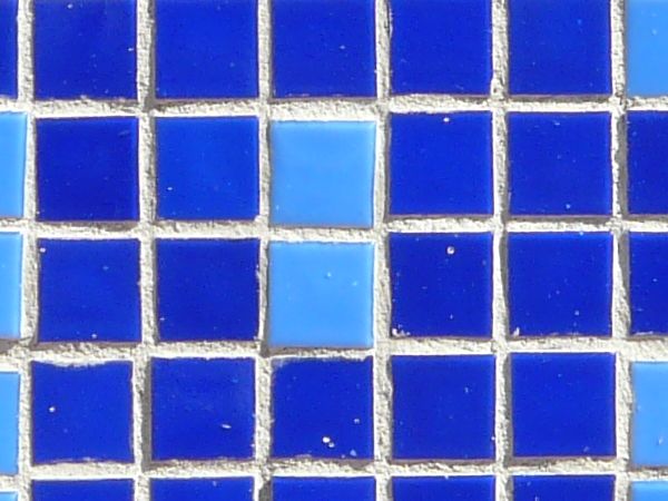 Seamless texture of small, square tiles in blue tones set evenly in white grout.