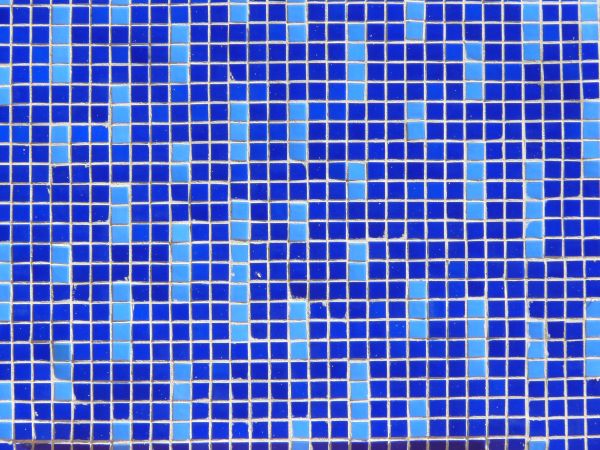 Seamless texture of small, square tiles in blue tones set evenly in white grout.