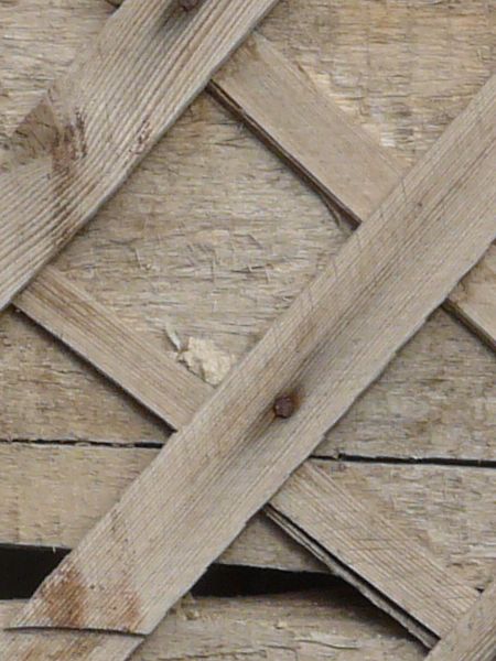 Wall texture consisting of thin, wooden planks set in consistent diamond patterns.