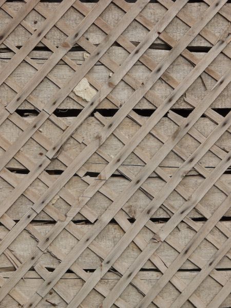 Wall texture consisting of thin, wooden planks set in consistent diamond patterns.