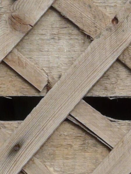 Wall texture consisting of thin, wooden planks set in consistent diamond patterns.