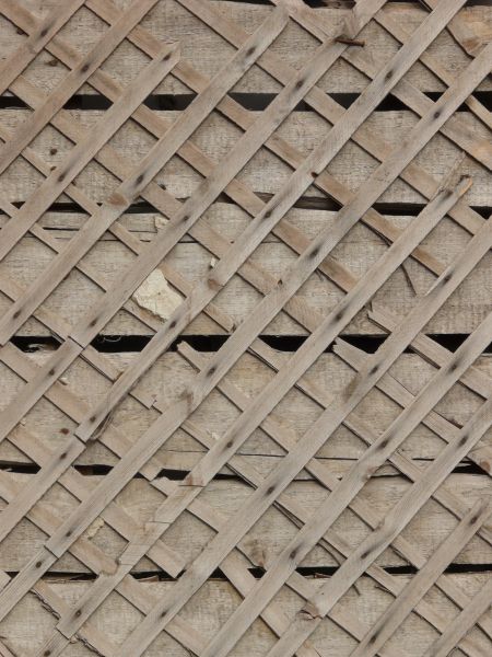 Wall texture consisting of thin, wooden planks set in consistent diamond patterns.